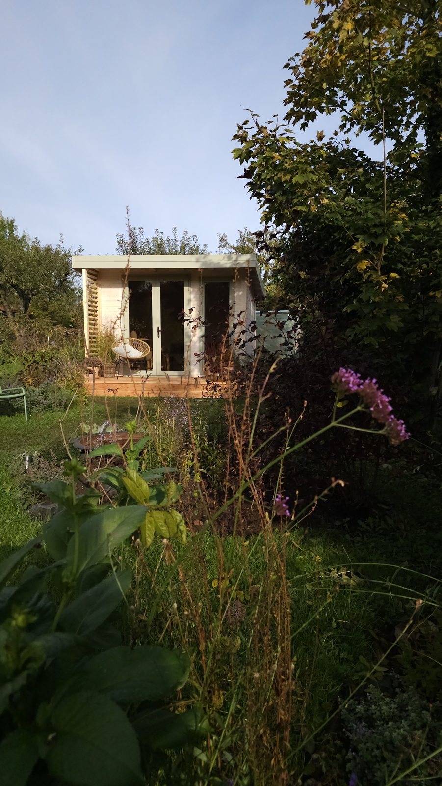 Gartenhaus umgeben von Blumen und Grün